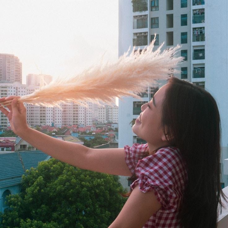 Avery Singh, Lead Design Curator at Ember Fern Wood Thistle, reviewing corporate floral arrangements